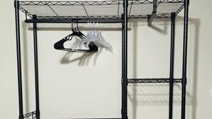 A metal wire shelving unit with multiple levels, a power outlet, and a box of puzzles on the bottom shelf. - Charming cozy studio in Austin (Austin)
