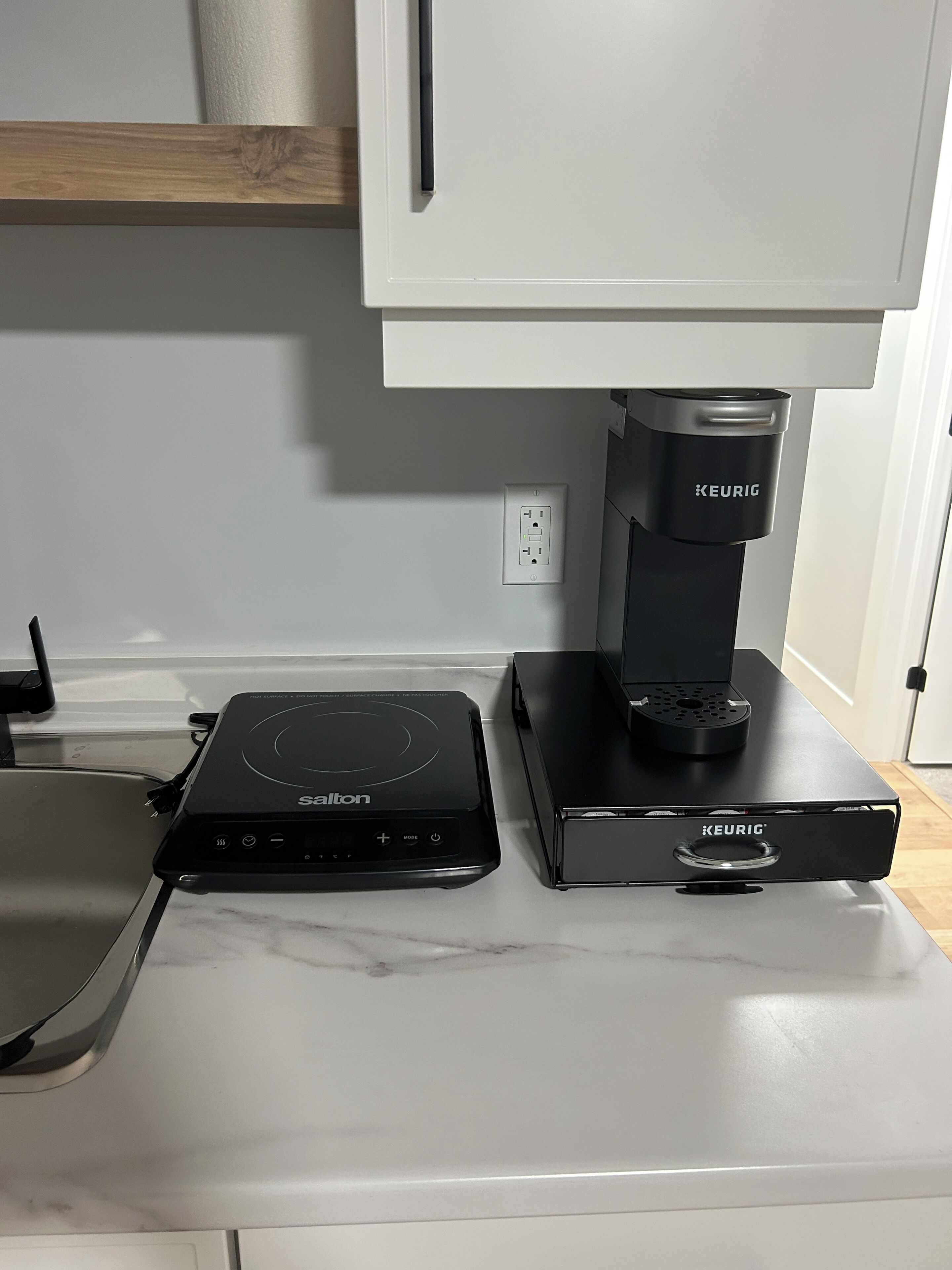 Une cuisine équipée d’un plan de travail, d’une machine à café et d’une bouilloire.