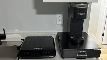 Une cuisine équipée d’un plan de travail, d’une machine à café et d’une bouilloire.