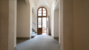 A hallway with a wooden door at the end, leading to a staircase. - Dimora San Paolino in Center Town (Lucca)