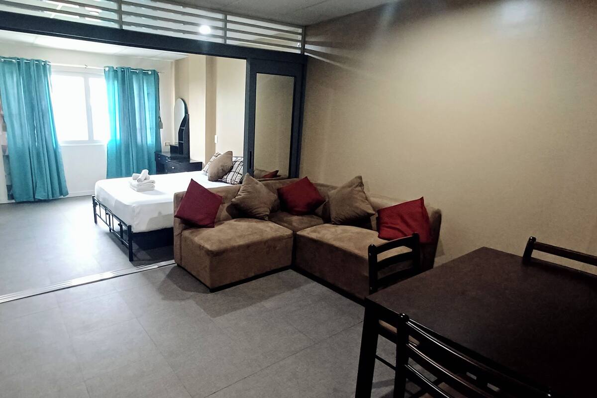 Une chambre d’hôtel moderne équipée d’un lit, d’un canapé, d’une table à manger et d’un miroir.