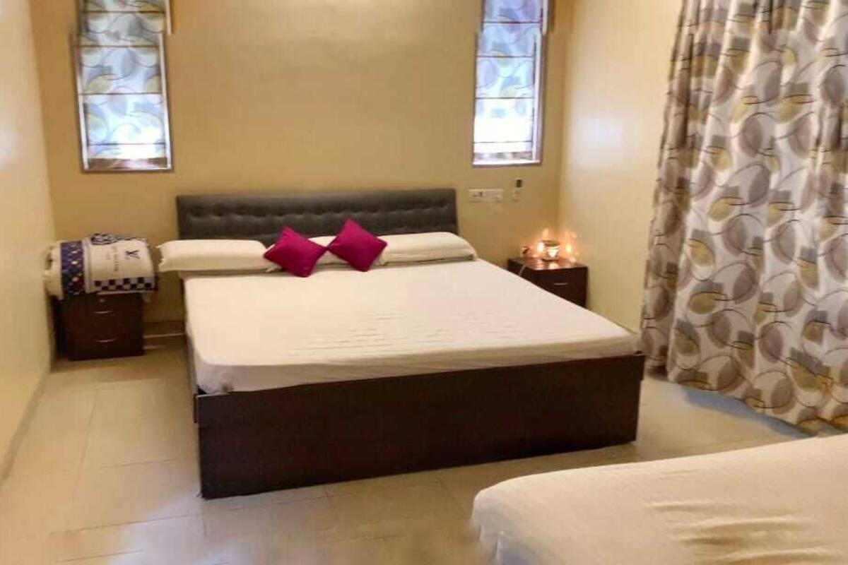 Camera da letto con un letto grande, due comodini, un tavolino e una finestra con vista, oltre a una tenda.