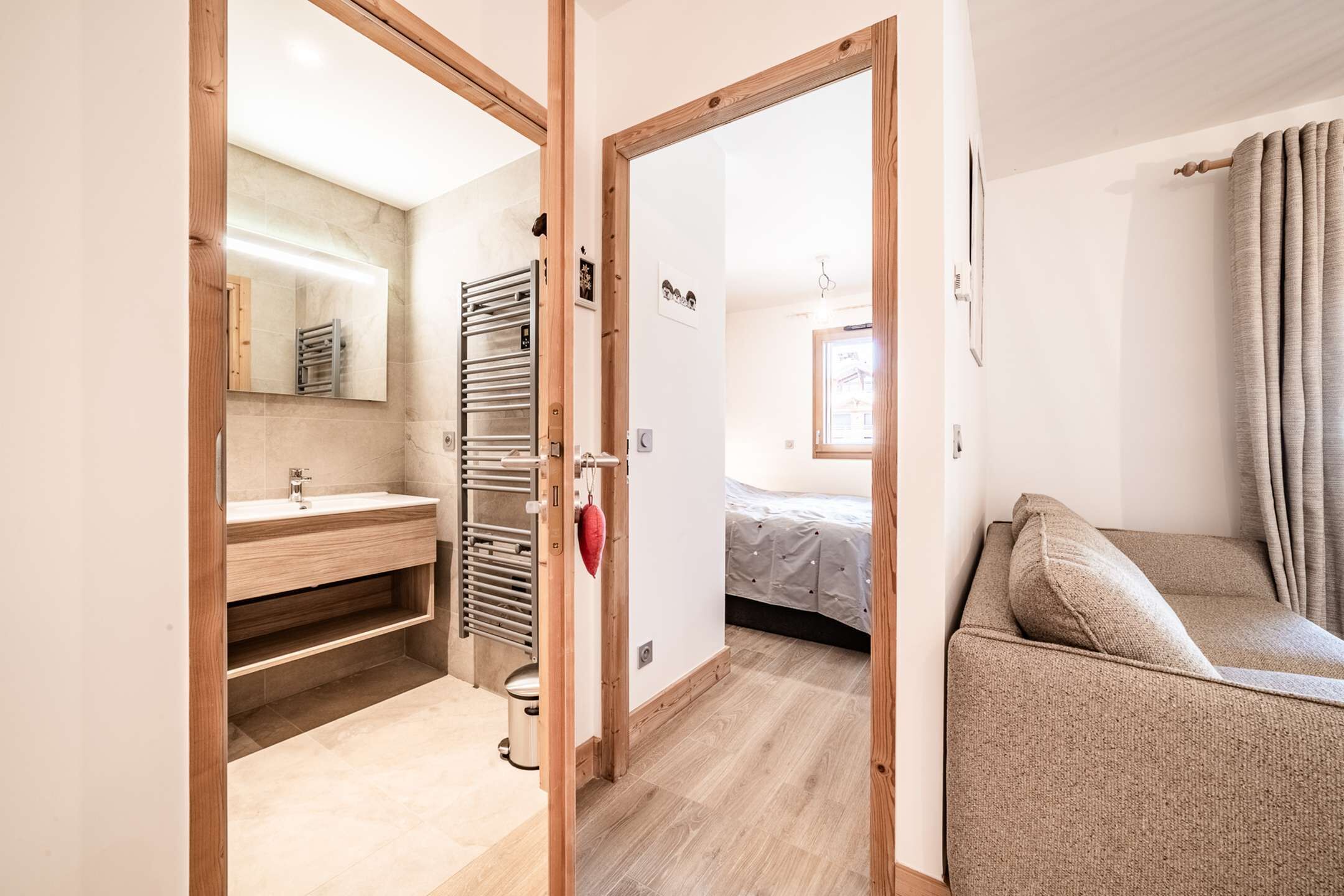 Une salle de bain moderne avec un meuble-lavabo en bois, un porte-serviettes et un miroir.