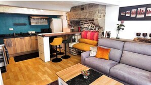 Un espacio habitable compacto con cocina, sofá y una mesita de centro.