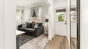 Una sala de estar moderna con un sofá gris, una mesa de centro y una alfombra estampada.