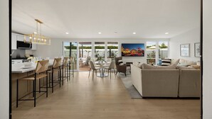 Ein modernes Wohnzimmer mit Sofa, Essbereich und Küche.