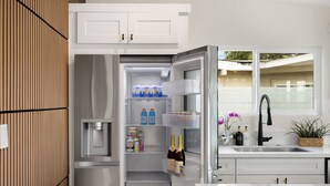 Eine moderne Küche mit Einbaukühlschrank, Spüle und Fenster.