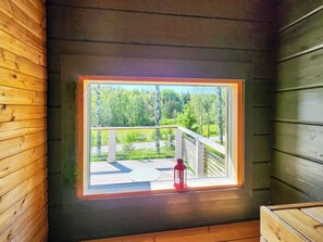 Una habitación con ventana que da a una terraza y un bosque.
