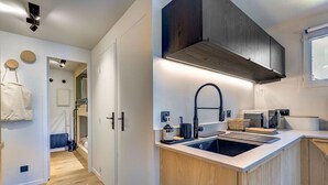 Una cocina moderna con un lavaplatos integrado, armarios de madera y un grifo negro.