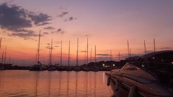 Een jachthaven in de zonsondergang, met verschillende zeilboten aanmeren.