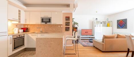 Un appartement moderne comprenant une cuisine, un coin repas et un salon.