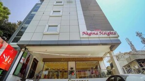 Un edificio moderno con un letrero que indica 'Nagina Heights' en la fachada.