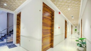 Un pasillo con puertas de madera, una escalera y una planta en maceta.