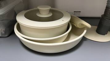 A set of stacked white bowls with lids, placed on a grey surface.