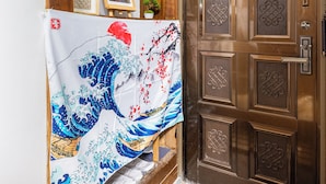 A traditional Japanese room with a wooden door, a tatami mat floor, and a shoji screen.