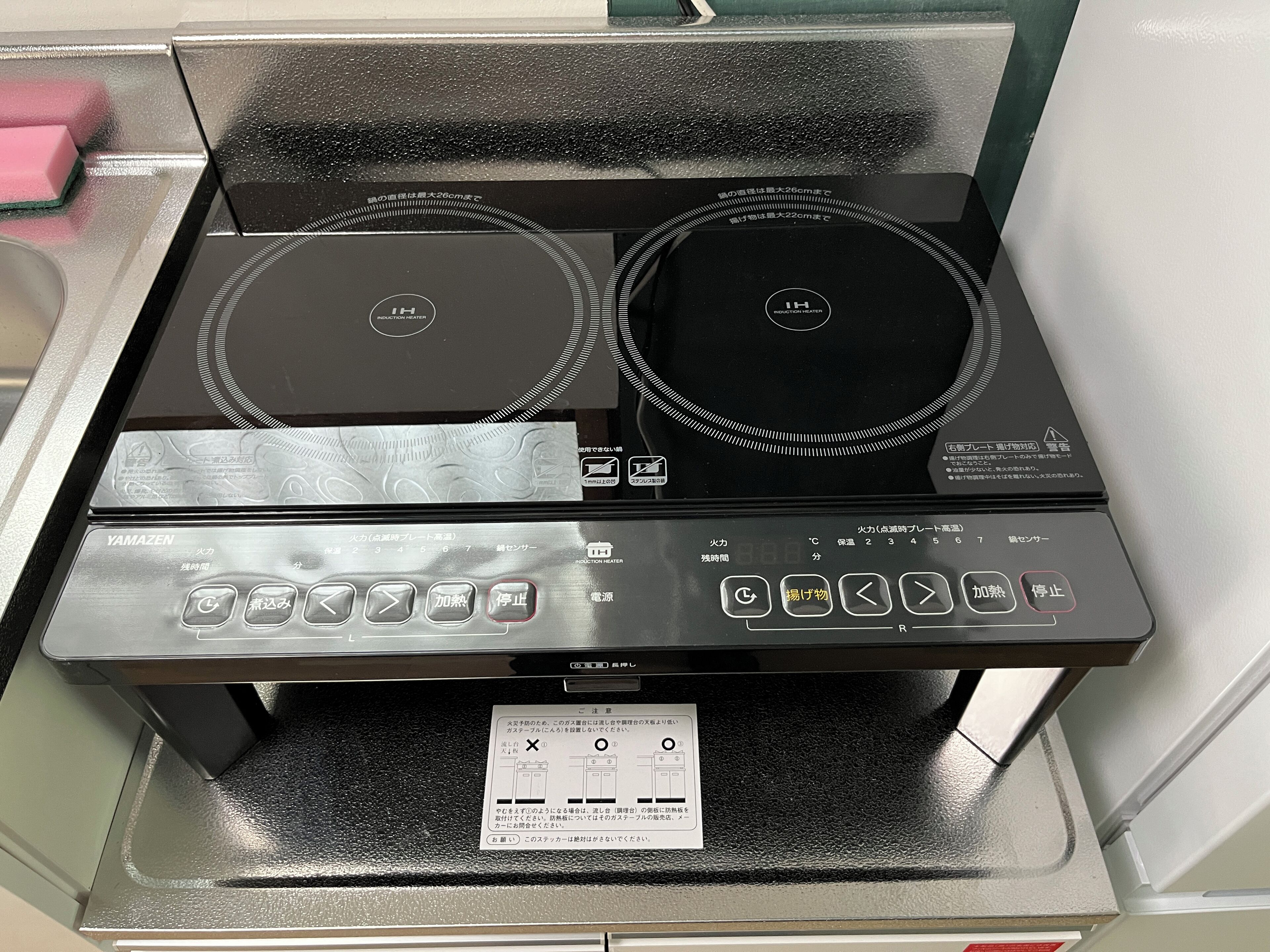 An induction cooktop with a control panel and a safety lock.