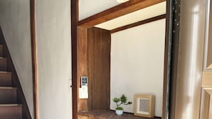 A wooden staircase leading to a room with a built-in shelf unit, a small potted plant, and a framed picture.