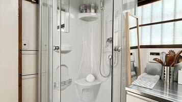 A modern bathroom with a glass-enclosed shower, a sink, and a toilet.