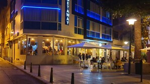 A modern building with a 'GETAWAY' sign, outdoor seating, and a paved area.