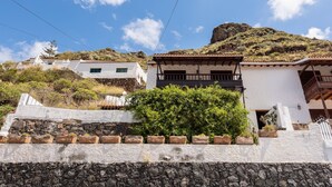 Una proprietà collinare con edifici bianchi, mura in pietra e una roccia particolarmente evidente.