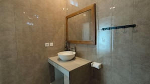 A bathroom with a white sink, a mirror, and a towel rack. - Dharma Suweta (Ubud)