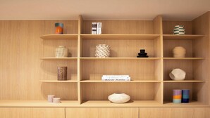 Una estantería de madera con varios objetos decorativos y libros.