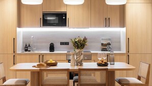 Una cocina moderna con armarios de madera, microondas integrado y una isla central con asientos.