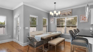 A dining area with a wooden table, wicker chairs, and a bench.
