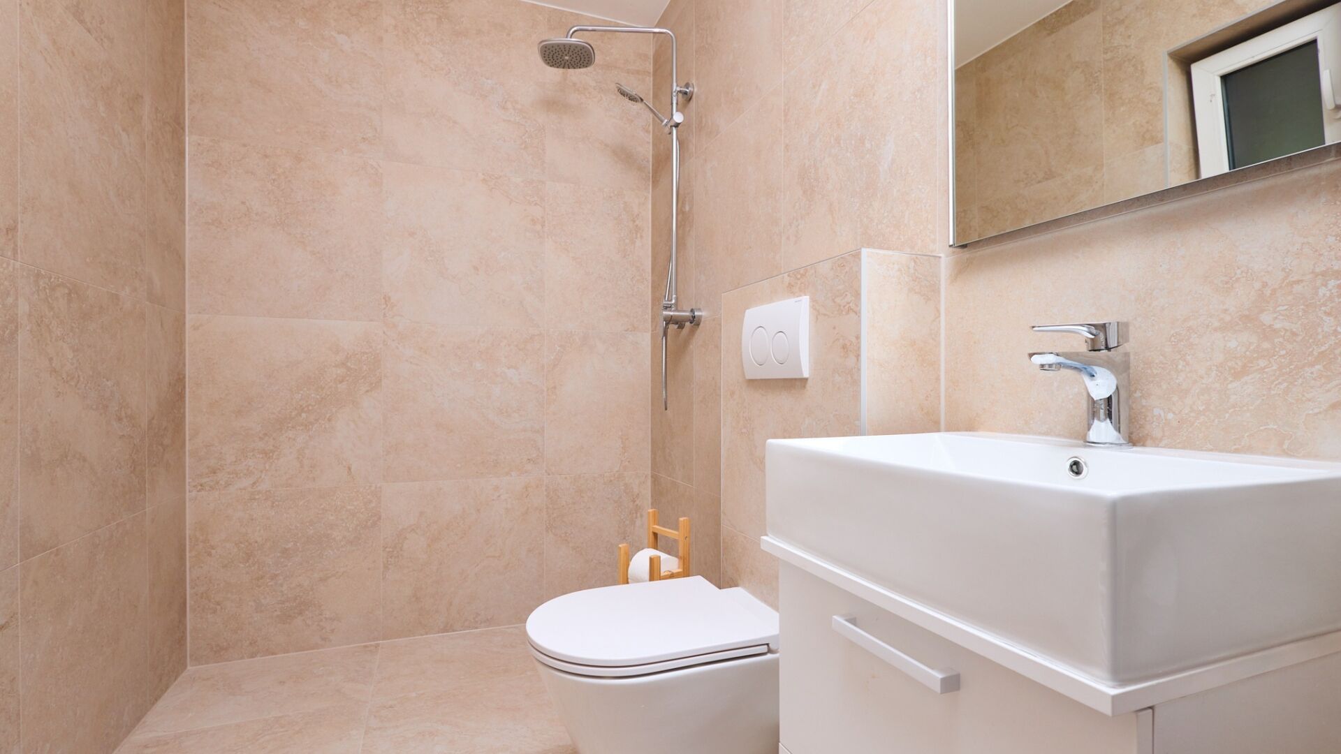 Une salle de bain avec douche, toilettes et lavabo.
