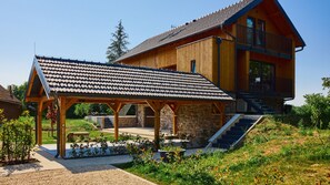 Una casa de madera con un porche cubierto, paredes de piedra y una escalera que lleva a un balcón.