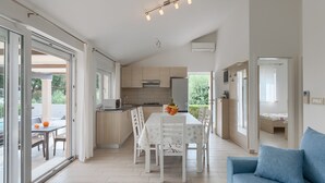 A modern kitchen with a dining area, a blue sofa, and a view of the outdoors. - Villa Kliman by Villas Guide (Medulin)