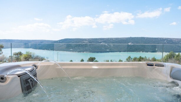A hot tub with a clear view of a lake and hills in the background. - Vila Laguna Blu by Villas Guide (Trget)