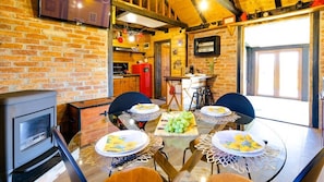 A dining area with a glass table, four chairs, and a fruit platter.
