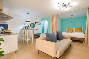 Un espacio habitable compacto con kitchenette, comedor y dormitorio.