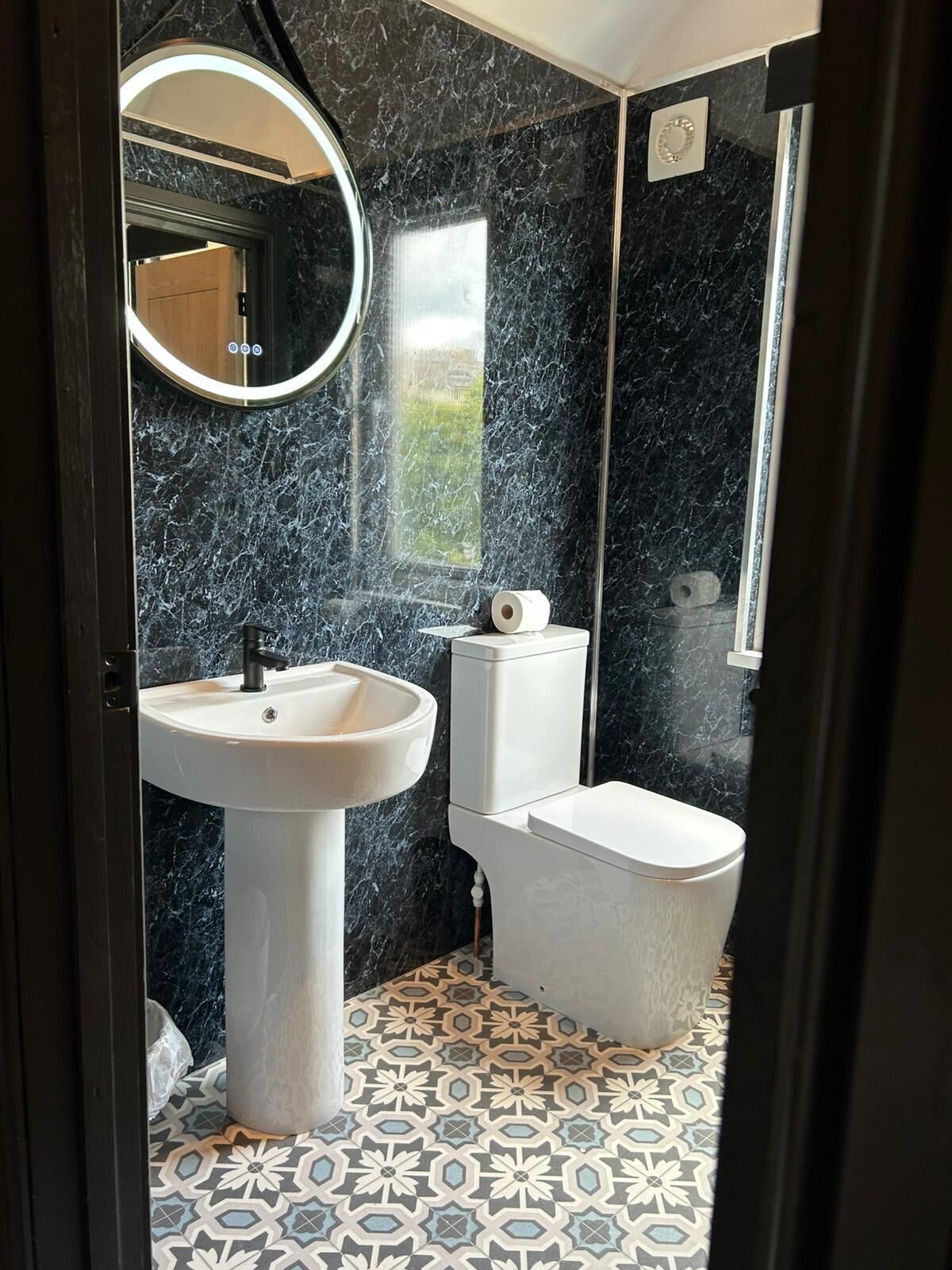 A bathroom with a white pedestal sink, a toilet, and a bathtub.