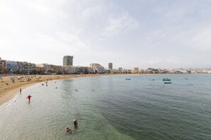 A beach with clear water, people swimming, and boats. - Apartment in Las Palmas near Las Canteras Beach (Las Palmas de Gran Canaria)