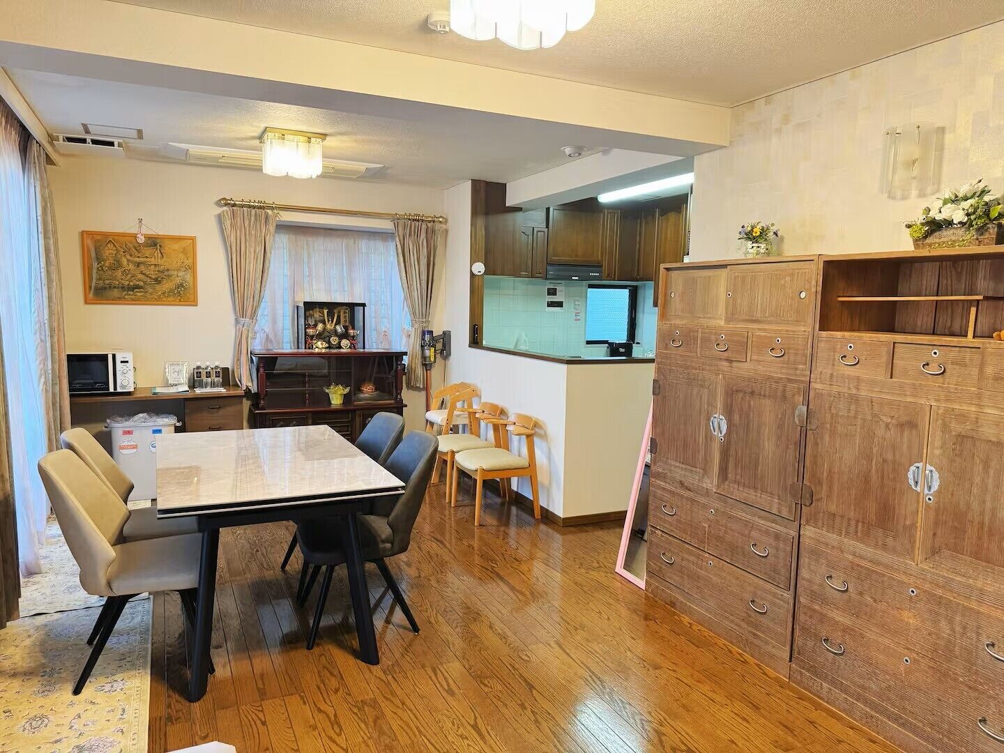 Un espacio habitable pequeño con comedor, cocina y un gran armario de madera.