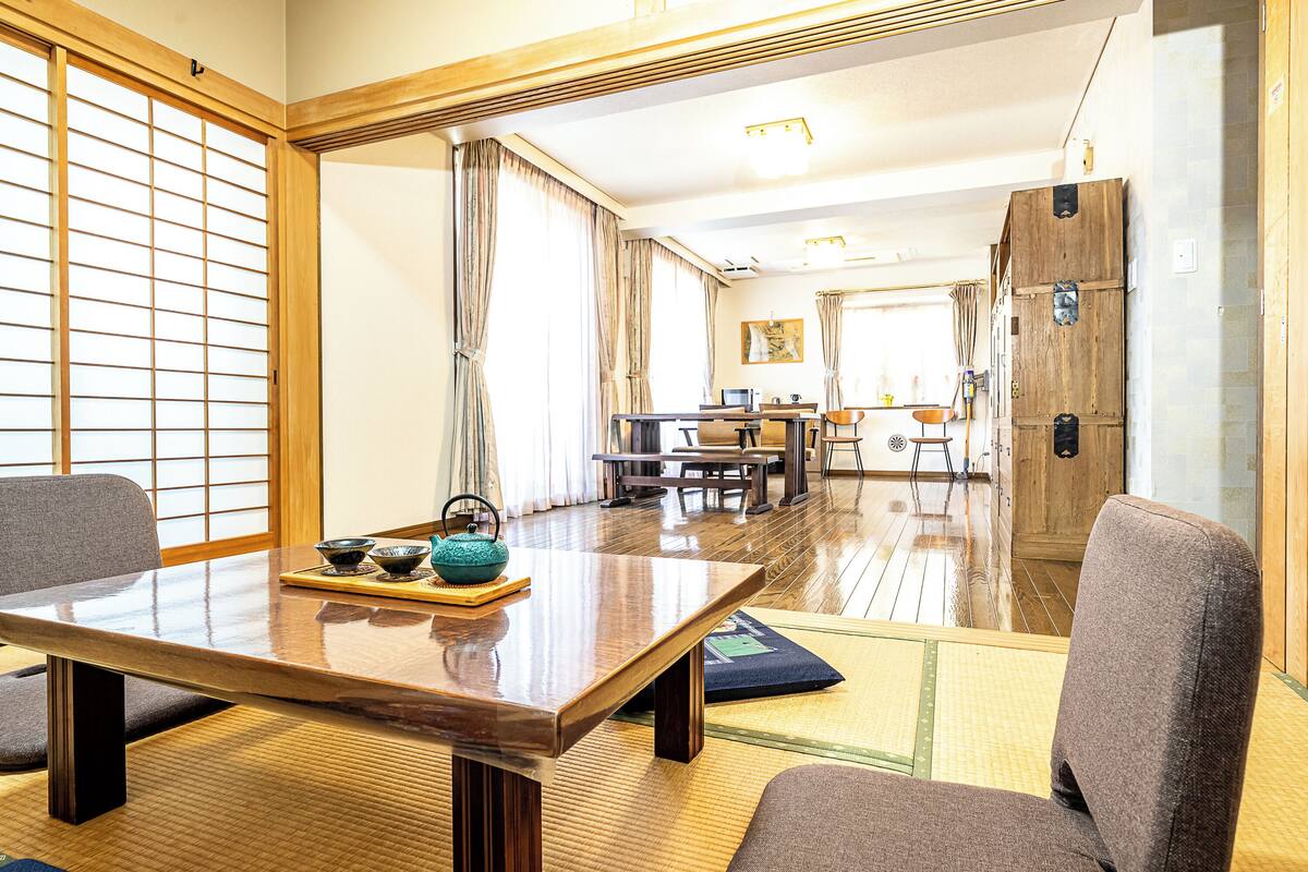 A traditional Japanese-style room with tatami flooring, a low wooden table, and a sliding door with a grid pattern.