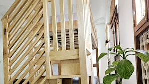 A wooden staircase with a simple design, a potted plant, and a tiled floor. - Hello Rafiki House - Stonetown (Zanzibar Town)