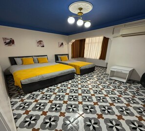 A bedroom with two beds, a ceiling fan, and patterned floor tiles. - Armagan Suite Taksim (Istanbul)