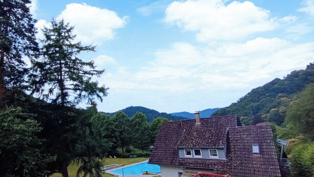 A house with a swimming pool, a red play structure, and a grassy yard. - Apartment with panoramic balcony with reading material, games and fitness room (Gernsbach)