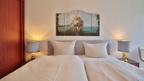 Une chambre d’hôtel avec un lit, deux lampes de chevet et un tableau accroché au mur.