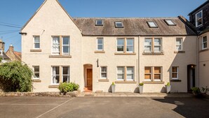 A two-story building with a pitched roof, multiple windows, and a small entrance. - Kidston Court (No 9) (St Andrews)