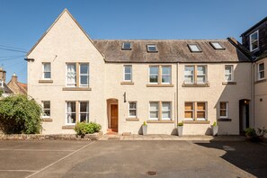 A two-story building with a pitched roof, multiple windows, and a small entrance. - Kidston Court (No 9) (St Andrews)