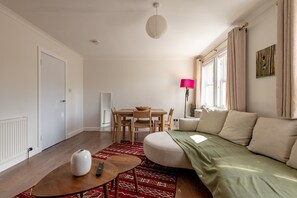 Ein modernes Wohnzimmer mit einer Couch, einem Esstisch und einem Couchtisch.