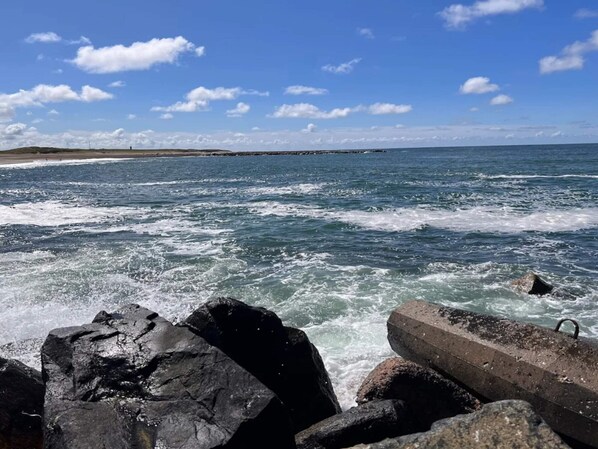 A rocky shoreline with waves crashing against the rocks.