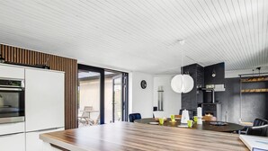 Une cuisine moderne dotée d’un plan de travail en bois, de meubles blancs et d’un four encastré.
