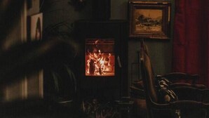 A cozy room with a fireplace, framed pictures on the wall, and a hanging light fixture. - The Notebook Haus in Omeo (Omeo)