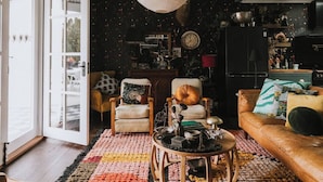 A cozy living room with a large window, a wooden coffee table, and a leather sofa. - The Notebook Haus in Omeo (Omeo)