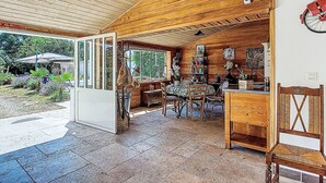 Un interior de madera con comedor, cocina abierta y vistas al jardín.